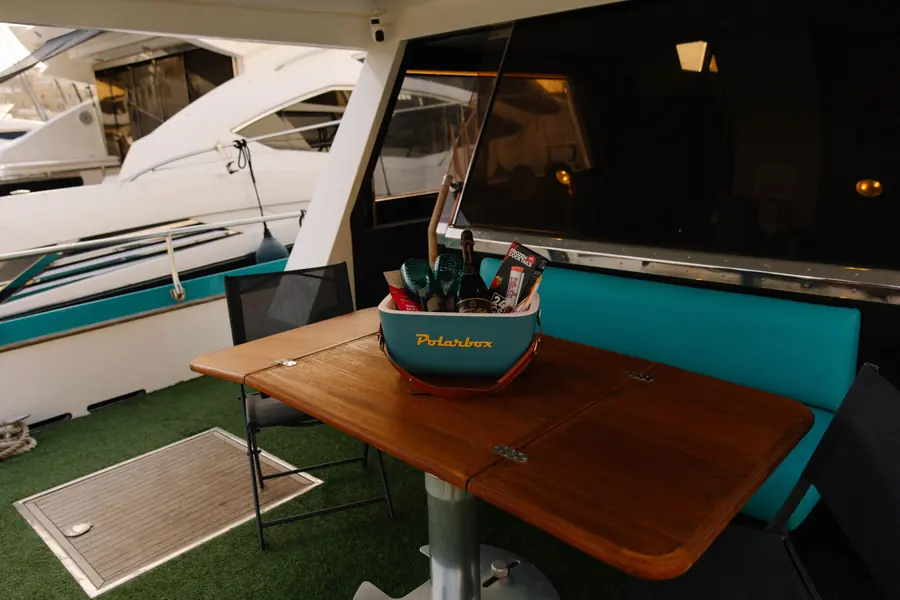 Cockpit with teak table, teal bench and a welcome cooler