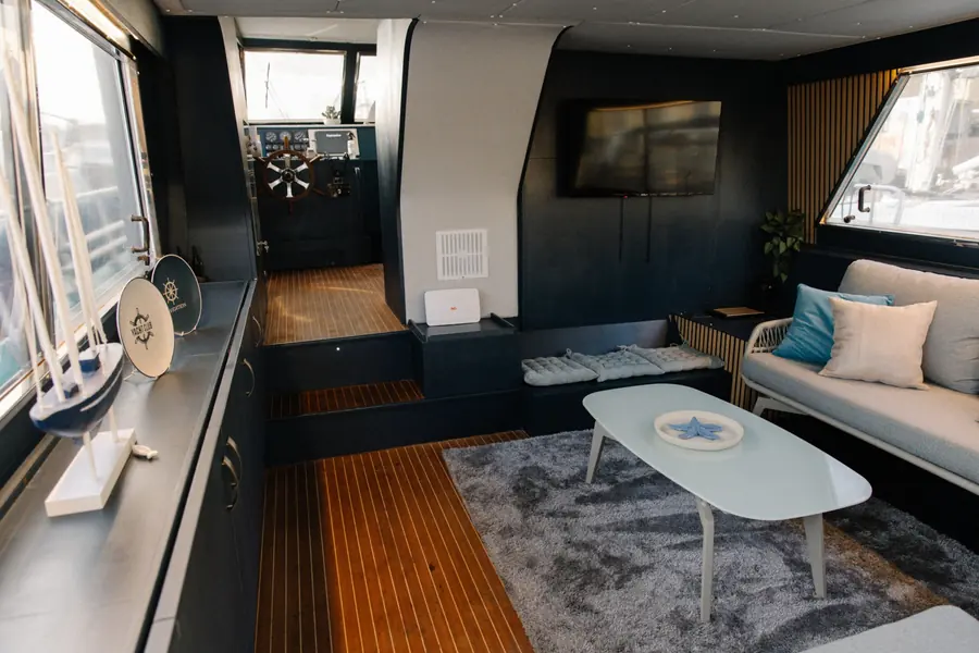 Saloon with Smart TV, teak floor and view towards the helm