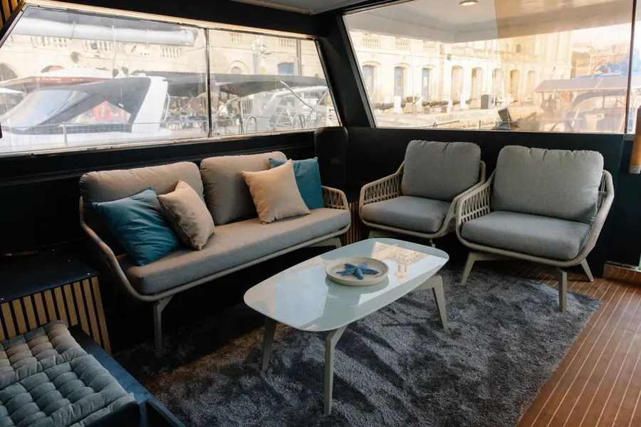 Saloon with sofa, armchairs and panoramic windows onto the marina