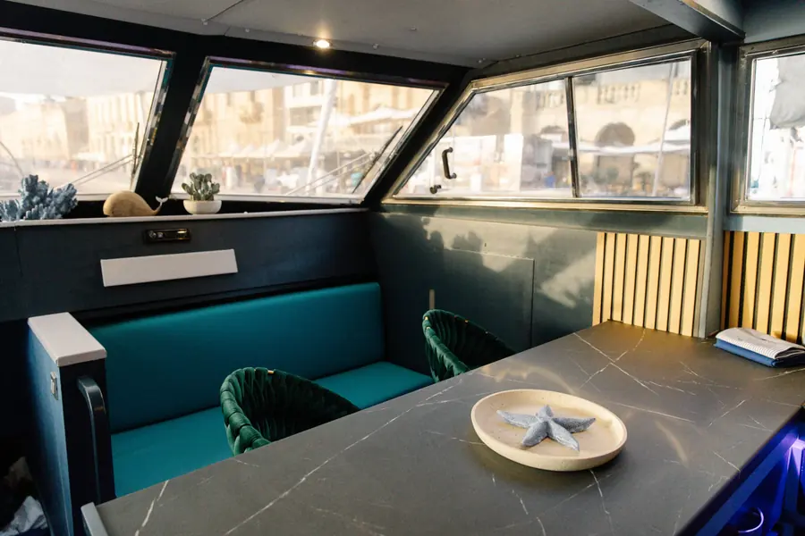 Dinette with teal bench seating beside the kitchen counter