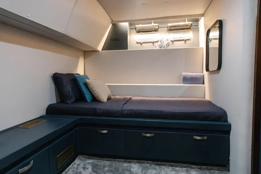Bright aft cabin with single bed and wall mirror
