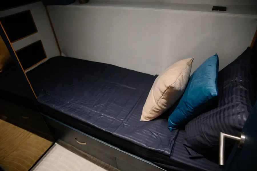 Single cabin with bed and decorative cushions
